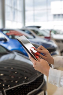 Bayi showroom dijital tablet kullanarak kadın satıcı. Dokunmatik ekran dijital tablet. Modern çalışma süreci.