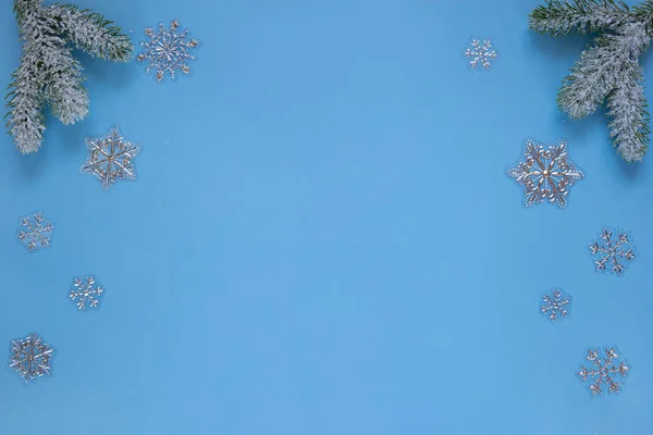 青い背景に孤立した松や雪片の雪の小枝。クリスマスと新年の概念。テキストのコピースペース. — ストック写真