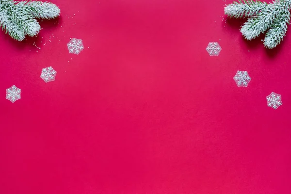 Raminhos nevados de pinheiro e flocos de neve isolados no fundo vermelho. Conceito de Natal e Ano Novo. Espaço de cópia para texto .. — Fotografia de Stock