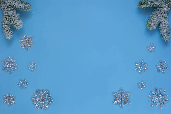 Raminhos nevados de pinheiro e flocos de neve isolados em fundo azul. Conceito de Natal e Ano Novo. Espaço de cópia para texto . — Fotografia de Stock