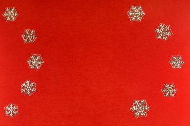 Kırmızı arka planda izole edilmiş dekoratif Noel kar taneleri. Noel ve yeni yıl kavramı. Metnin için boşluk kopyala.