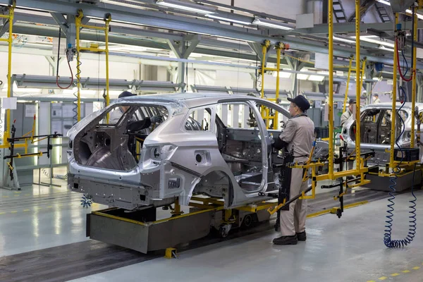 Rusya, İzhevsk - 14 Aralık 2019: Lada Otomobil Fabrikası İzhevsk. İşçiler yeni bir arabanın gövdesine kapılar koydular..