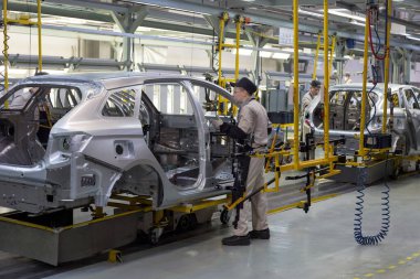 Rusya, İzhevsk - 14 Aralık 2019: Lada Otomobil Fabrikası İzhevsk. İşçiler yeni bir arabanın gövdesine kapılar koydular..