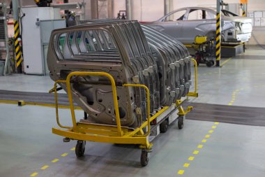 Russia, Izhevsk - December 14, 2019: LADA Automobile Plant Izhevsk. Doors for a new cars are standing on the cart. clipart