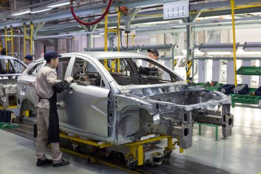 Rusya, İzhevsk - 14 Aralık 2019: Lada Otomobil Fabrikası İzhevsk. İşçi yeni bir arabanın kapılarını açıyor..