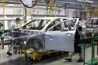 Rusya, İzhevsk - 14 Aralık 2019: Lada Otomobil Fabrikası İzhevsk. İşçiler yeni bir arabanın gövdesine kapılar koydular..