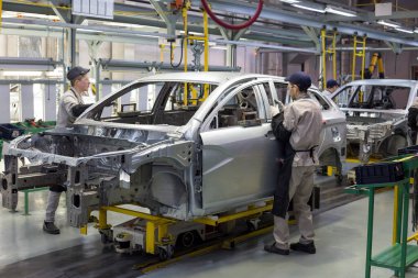 Rusya, İzhevsk - 14 Aralık 2019: Lada Otomobil Fabrikası İzhevsk. İşçiler yeni bir arabanın gövdesine kapılar koydular..