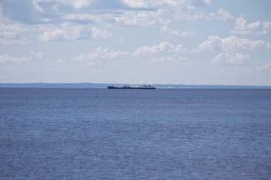 Bir mavna geniş mavi bir nehir boyunca kargo taşıyor. Dünya gezegeni.