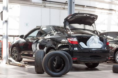 Araç hidrolik asansörün yanında duruyor. Atölye vagonunda planlanmış değiştirme ve tekerlek hizalaması. Modern servis.