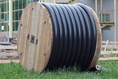 Benzin ve su için bobindeki büyük polietilen borular yere saçılmış. Onarım çalışmaları.