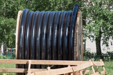 Benzin ve su için bobindeki büyük polietilen borular yere saçılmış. Onarım çalışmaları.