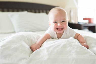 yatakta erkek gülümseyen bebek