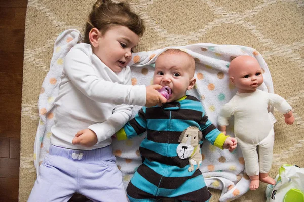 Overhead image of siblings and doll — Stock Photo, Image