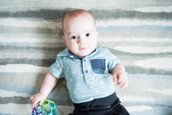 Baby Boy Blue Shirt Looks Camera While Laying Modern Striped — Stock Photo, Image