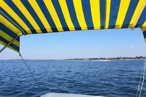 Blauwe en gele tent boven het wateroppervlak — Stockfoto