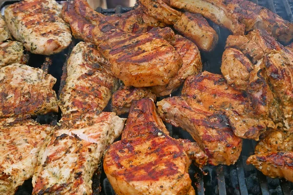 Beaucoup de morceaux de viande sont grillés sur des barres métalliques — Photo