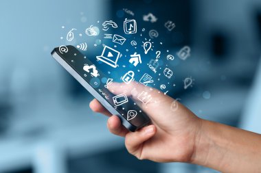 Medya simgeleri ve sembolleriyle el ele tutuşan akıllı telefon 
