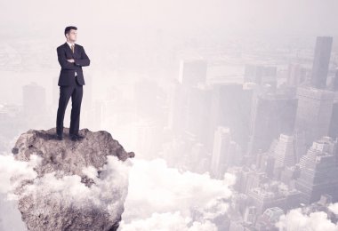 Kayanın üzerinde duran kazanan iş kişi