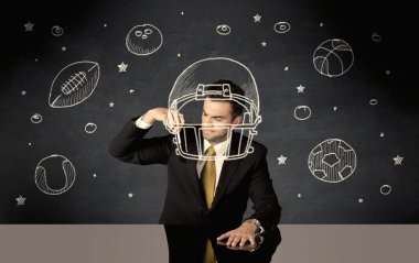 İş adamı miğfer ve spor topu çiziyor.