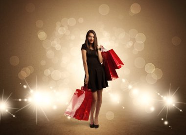 Parlak ışıklarda çantalı alışveriş yapan kadın.