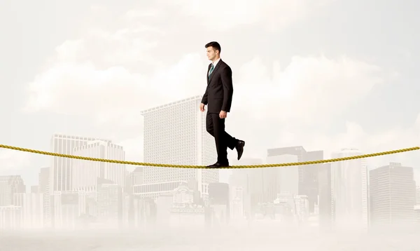 Business person balancing on golden rope — Stock Photo, Image