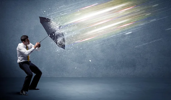 Affärsman som försvarar ljusstrålar med paraplykoncept — Stockfoto