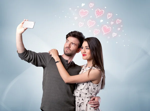 Verliebtes Paar macht Selfie mit rotem Herz — Stockfoto