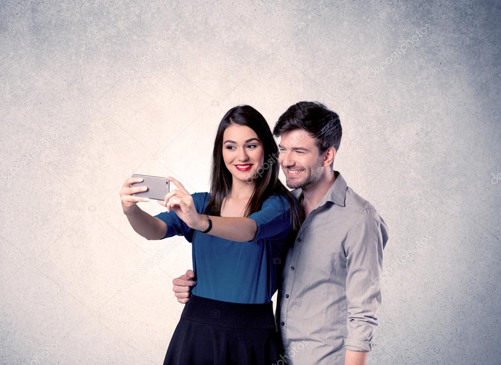 Happy couple taking selfie with clear wall
