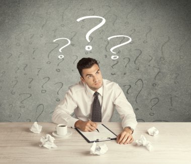 İş adamı soru işaretiyle masada.