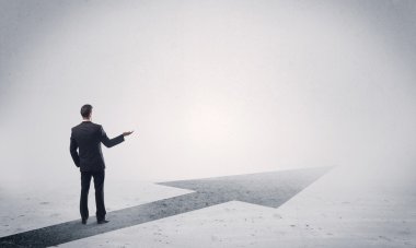 Ayakta duran satıcı elinde okla ileriye bakıyor.