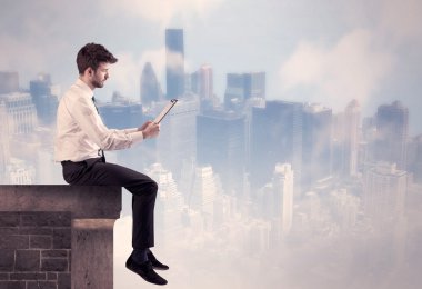 Yüksek bir binanın tepesinde oturan satıcı.