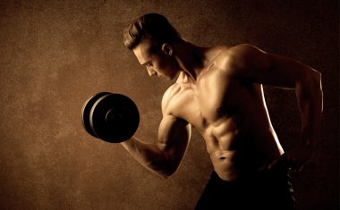 Kas formundaki vücut geliştirici sporcu ağırlık kaldırıyor 