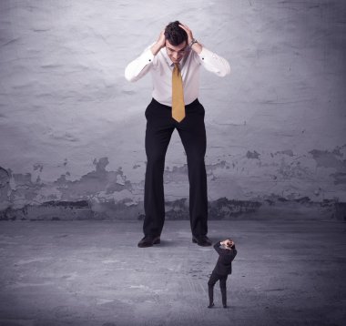 Kızgın büyük müdür küçük iş adamına bakıyor.