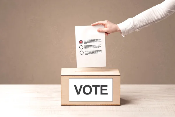 Fechar a mão masculina colocando voto em uma urna — Fotografia de Stock