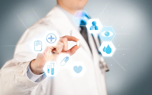 A doctor in white holding a pill — Stock Photo, Image