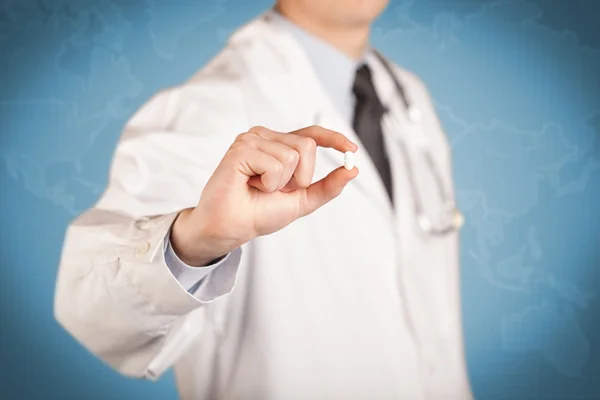 Médecin en blanc tenant une pilule — Photo