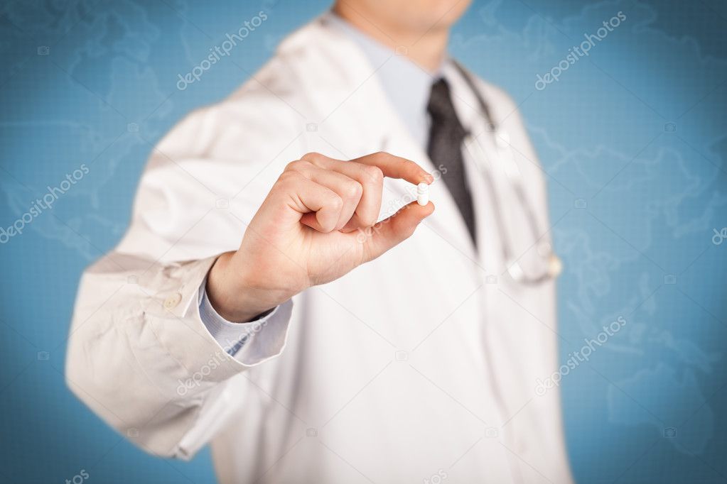 Doctor in white holding a pill