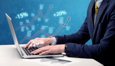 Satıcı dizüstü bilgisayarla grafikle çalışıyor.