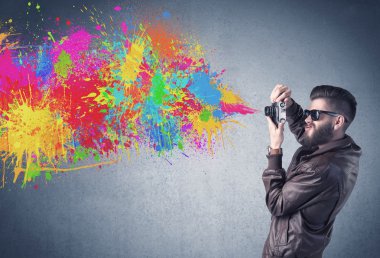 Kamera ve boya sıçratan hippi adam.