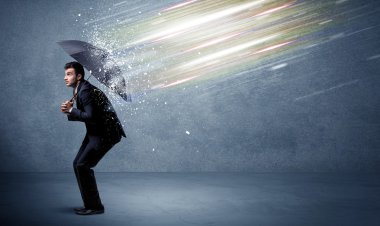 Şemsiye konseptiyle ışık demetlerini savunan iş adamı
