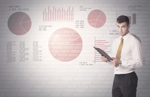 Pie charts and numbers on wall with salesman — Stock Photo, Image