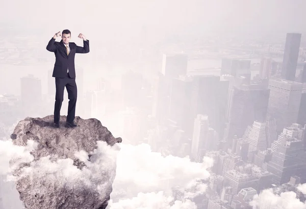 Победитель деловой человек, стоящий на скале — стоковое фото