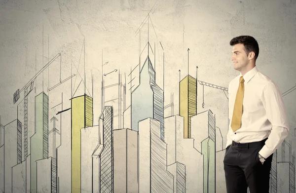 Businessman standing with drawn cityscape — Stock Photo, Image