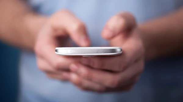 Jovem segurando smarthphone na mão — Fotografia de Stock