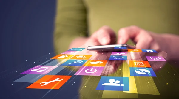 Frau hält Smartphone mit bunten Applikationssymbolen in der Hand — Stockfoto