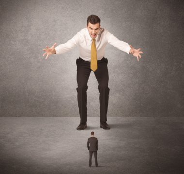 Büyük iş adamı küçük işçilere bakıyor.