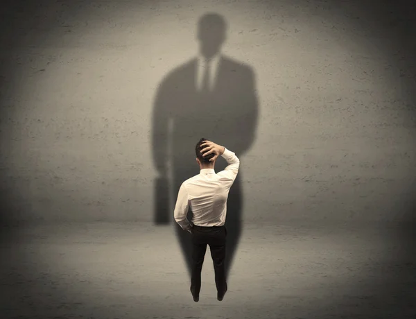 Businessman looking at big shadow concept — Stock Photo, Image