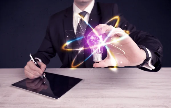 Businessman holding a colorful light bulb — Stock Photo, Image