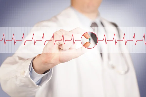 Een arts met een hartpil — Stockfoto