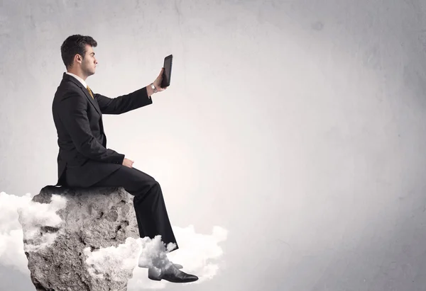Office worker sitting on top of a rock — Stock Photo, Image